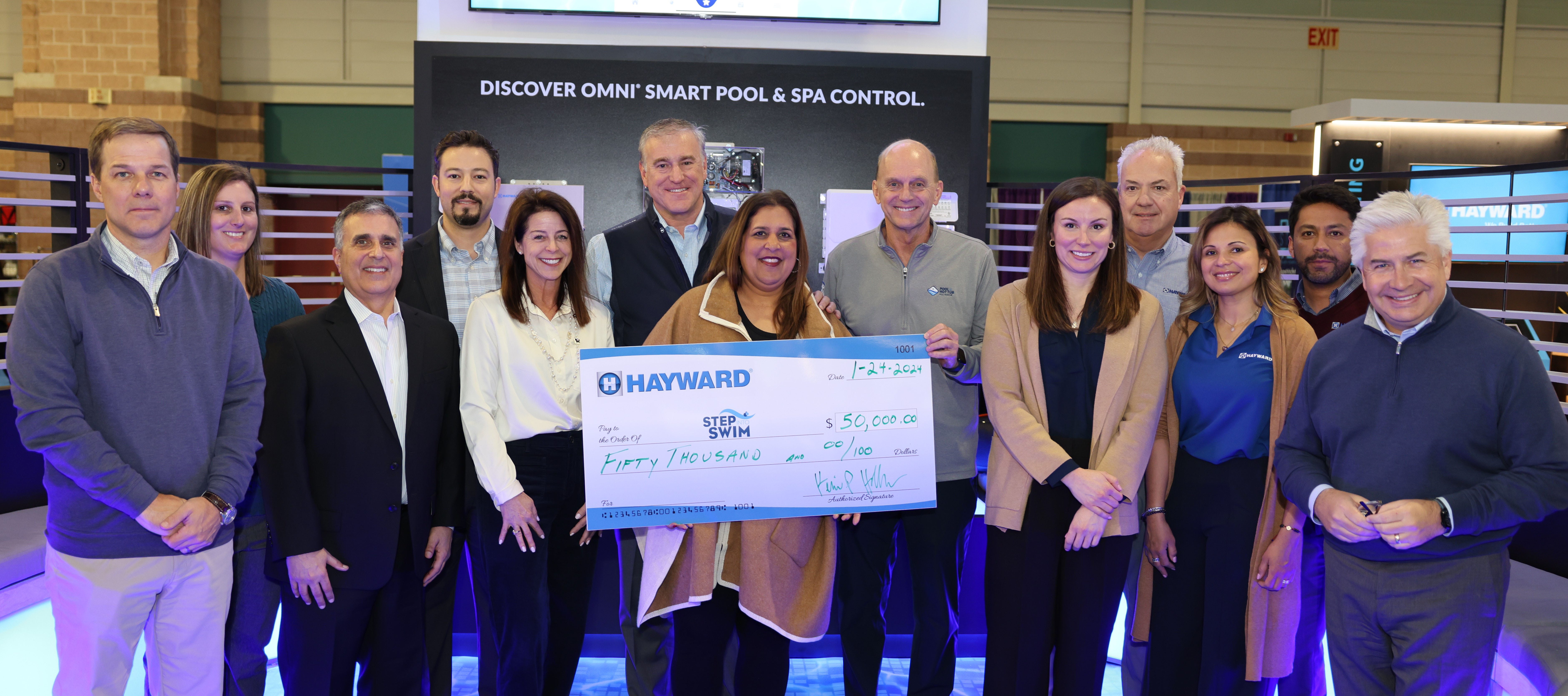 El equipo de Hayward y la Pool & Hot Tub Alliance presentan una donación a la iniciativa Step Into Swim con un cheque cuyo importe es considerable.